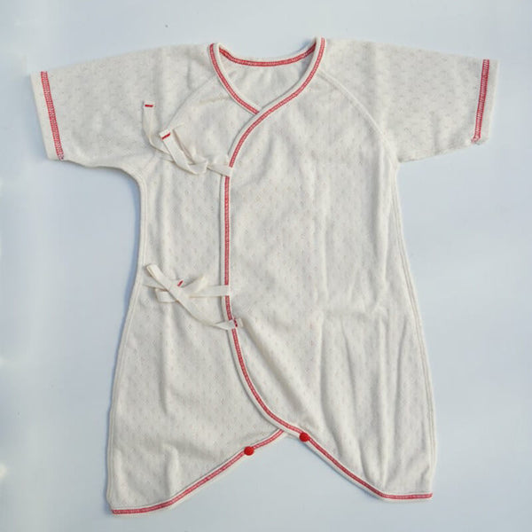 100% cotton pointelle, short sleeve, full-bodied onesie. Features a kimono-style two-ribbon closure, snap button closures along the legs, and exposed stitching Newborn to 1 year old Made in Japan 